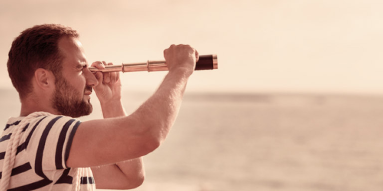 Man using a collapsible handheld telescope to view his scenery.