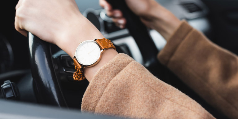 Lady’s hands on a steering wheel.